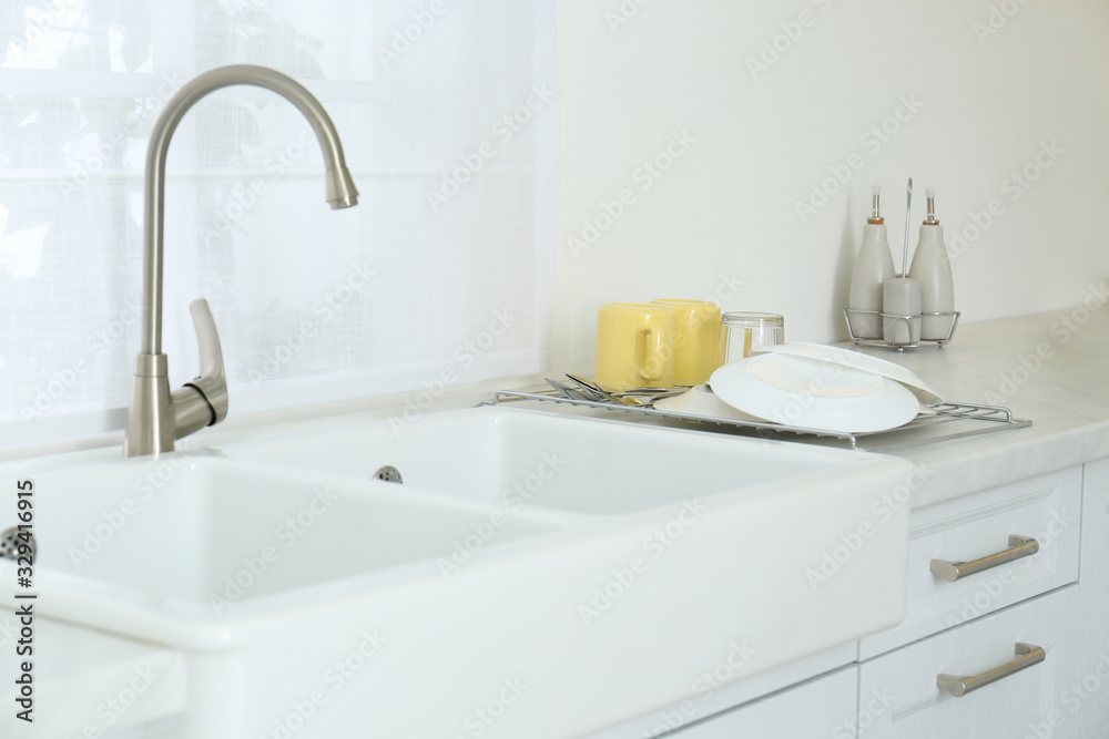 Poster Clean dishes drying on rack in modern kitchen