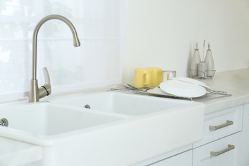 Clean dishes drying on rack in modern kitchen