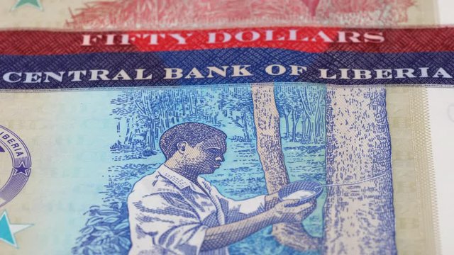 Liberia dollar notes slow tracking. Liberian currency. Slider shot, low angle. 4K