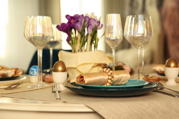Festive Easter table setting with decorated eggs in kitchen