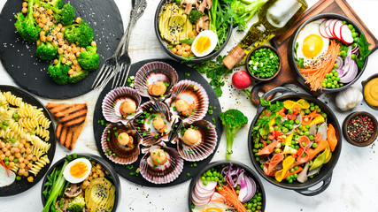 Assortment of food on white wooden background. Seafood, meat and vegetables.