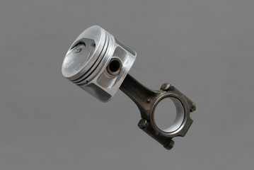 Car engine piston isolated on gray background.