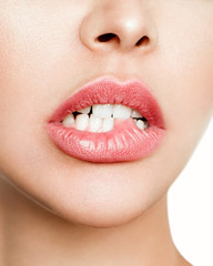 Fototapeta premium Licking lips. Close-up of young woman licking lips while isolated on white