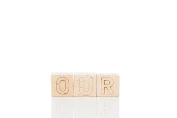 Wooden cubes with word our on a white background