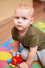 Portrait of a two year old boy on the background of toys.