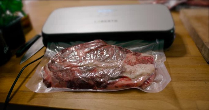 The vacuum packer shrink wraps the raw meat in preparation for sous-vide cooking