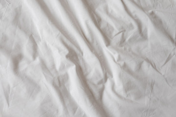 Background of white rumpled sheets. Bed linen with wrinkles in d