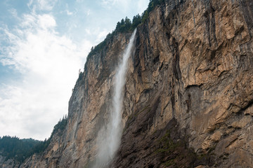 Fototapeta na wymiar Small mountain waterfall. Summer alpine mountain landscape