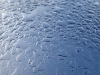 morning dew water drops ona black metallic surface