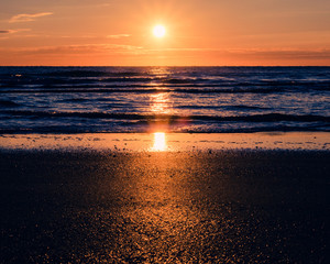 Fototapeta na wymiar Sunrise Shining Across a Calm Ocean