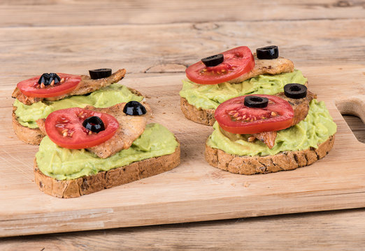 Sandwiches with avocado pasta, chicken breast fillet, tomatoes and olives.