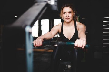 Fototapeta na wymiar Woman trains on a rowing machine