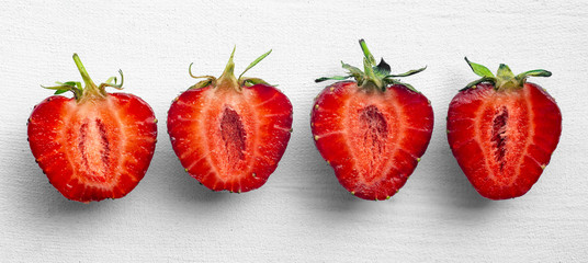 Halved ripe strawberries on a white background