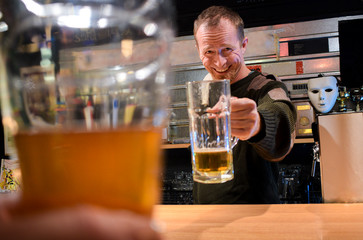 Bartender cheers with a beer in the bar