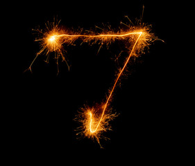 number seven written with a sparkler on a black background