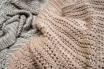 Fototapeta na wymiar Crumpled folded beige, brown knitted fabric of different colors background, woolen knitwear close up