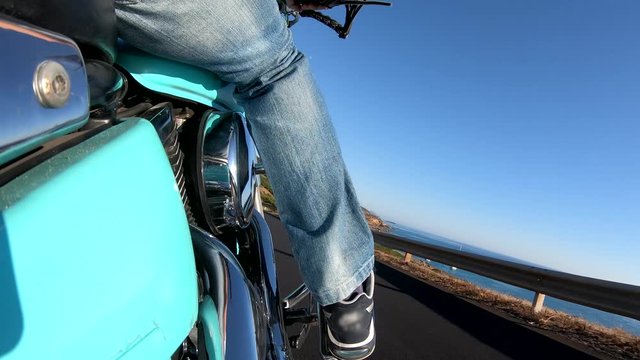 Motorcycle ride on a winding coastal road seen from the right side