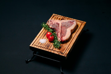 Raw meat steak t-bone on a black background.