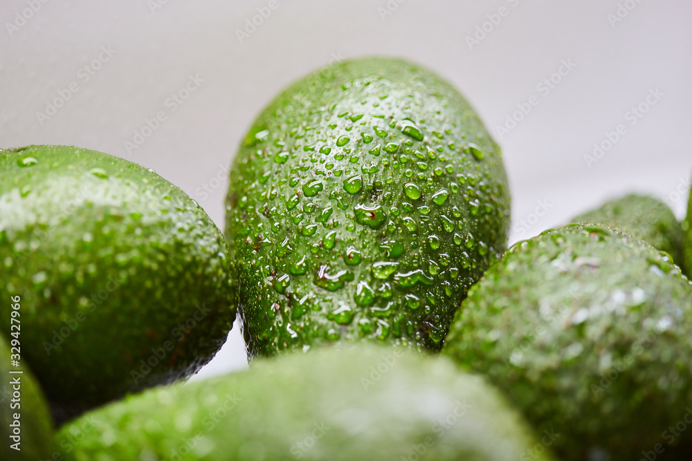 Wall mural fresh tropical avocado fruit with water drops close up (macro shot)