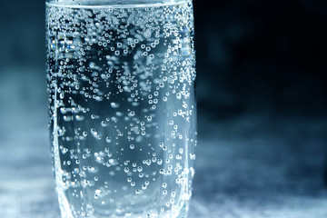 Glass of sparkling water on the grey background