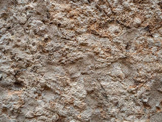 The surface of the old stone is rough and cracked. Natural stone background.