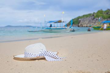 Hat on a white sandy beach. White sand. Sea traveling. Concept summer beach holiday.