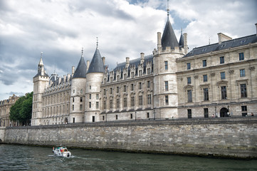 Fototapeta na wymiar Palace on stone embankment. Boat tour. Palais de la Cite in Paris France. Palace building with towers and spires. Monument of gothic architecture and design. Vacation and wanderlust in french capital