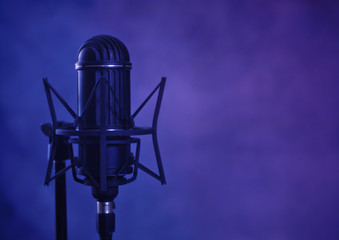 Retro ribbon microphone on a purple, grunge background with copy space