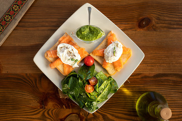 Sandwiches with tuna and green sauce on wooden table