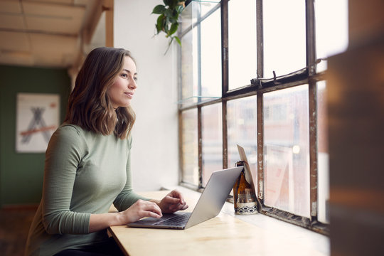 Beautyful Young Woman Is Sitting On A Café Trying To Study