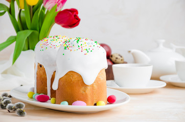 Easter composition. Easter Cake - Russian and Ukrainian Traditional Kulich with easter eggs on a light stone background. Paska Easter Bread. Selective focus. Horizontal orientation. Copy space
