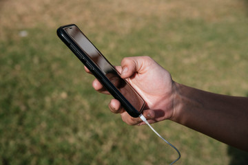 hand with cellphone in the grass