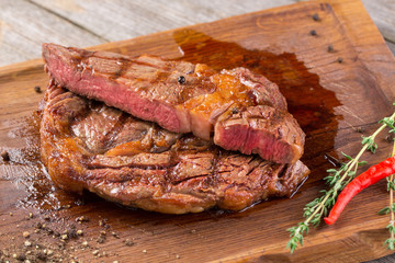 Cut Rib eye steak on wooden board, closeup