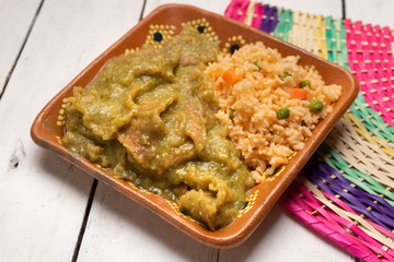 Mexican pork chicharron with green sauce and rice on white background