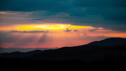 Foto op Canvas Amazing sunset with cloudy sly and the silhouette from hills in the black forest © Corri Seizinger