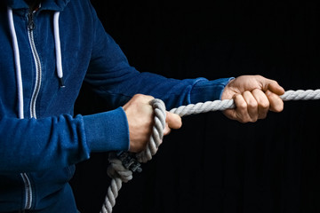 hands with a rope on a black background
