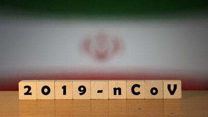 Flag of Iran with outbreak deadly coronavirus covid-19 in background. Wooden blocks with inscription 2019-nCov. Iran flag background with the spread of Coronavirus