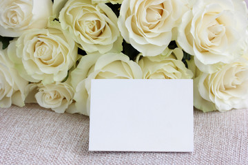 empty card against a background of delicate cream roses.
