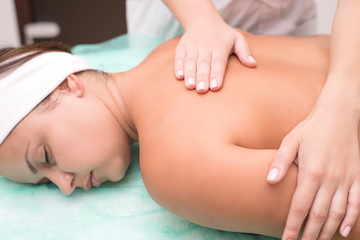 Fototapeta na wymiar masseur makes massage to a beautiful girl. Spa pleasure