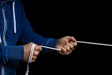 hands with a rope on a black background