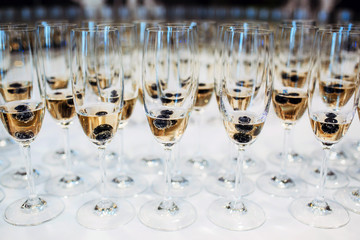Group of champagne glasses. Wedding venue welcome drink. Let the party begin. Event celebration empty copy space alcohol background. Blueberry in cocktail.