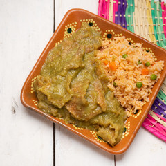Mexican pork chicharron with green sauce and rice on white background