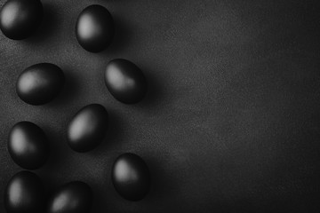 Black eggs on a black background. Easter minimalistic concept