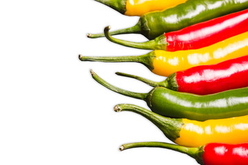 Color chili peppers. Hot spicy food ingredient. Red, yellow and green peppers isolated on white. Empty copy space vegetable background.