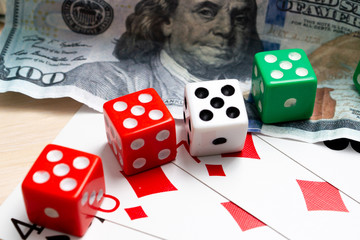 money dollars dice playing cards gambling on a light wooden table