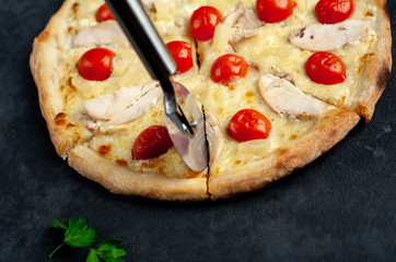 delicious pizza with pineapple, tomato, mozzarella cheese, chicken fillet on a stone background