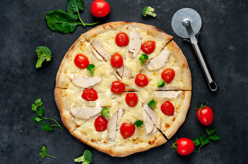 delicious pizza with pineapple, broccoli, tomatoes, mozzarella cheese, chicken fillet on a stone background