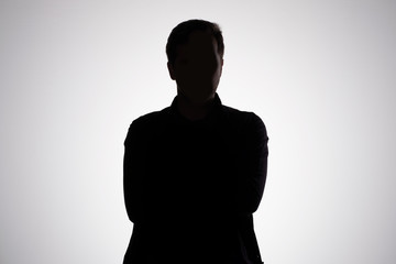 Man silhouette on gray studio wall. Studio shot