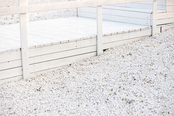 Decorative landscape. The wooden platform painted in white color. Marble chips are white.