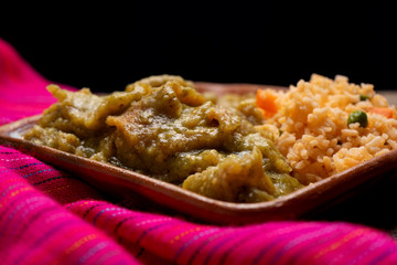 Mexican pork chicharron with green sauce and rice on wooden background